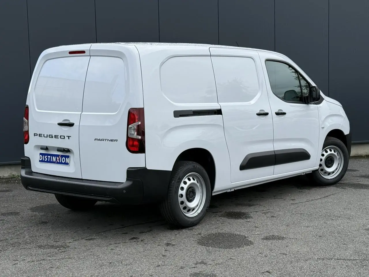Vue 3/4 arrière droite d'un utilitaire Peugeot Partner XL blanc avec porte latérale coulissante et jantes acier.
