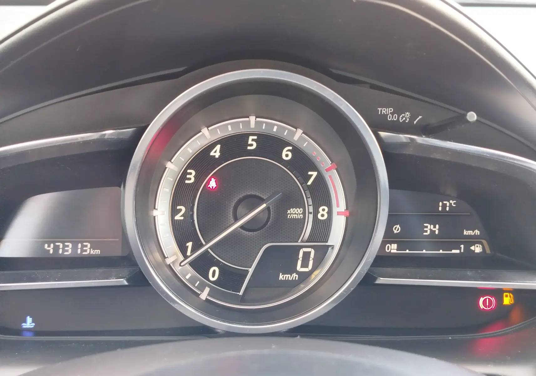 Vue rapprochée du tableau de bord du Mazda CX-3 2016, affichant compte-tours, vitesse et témoins lumineux.