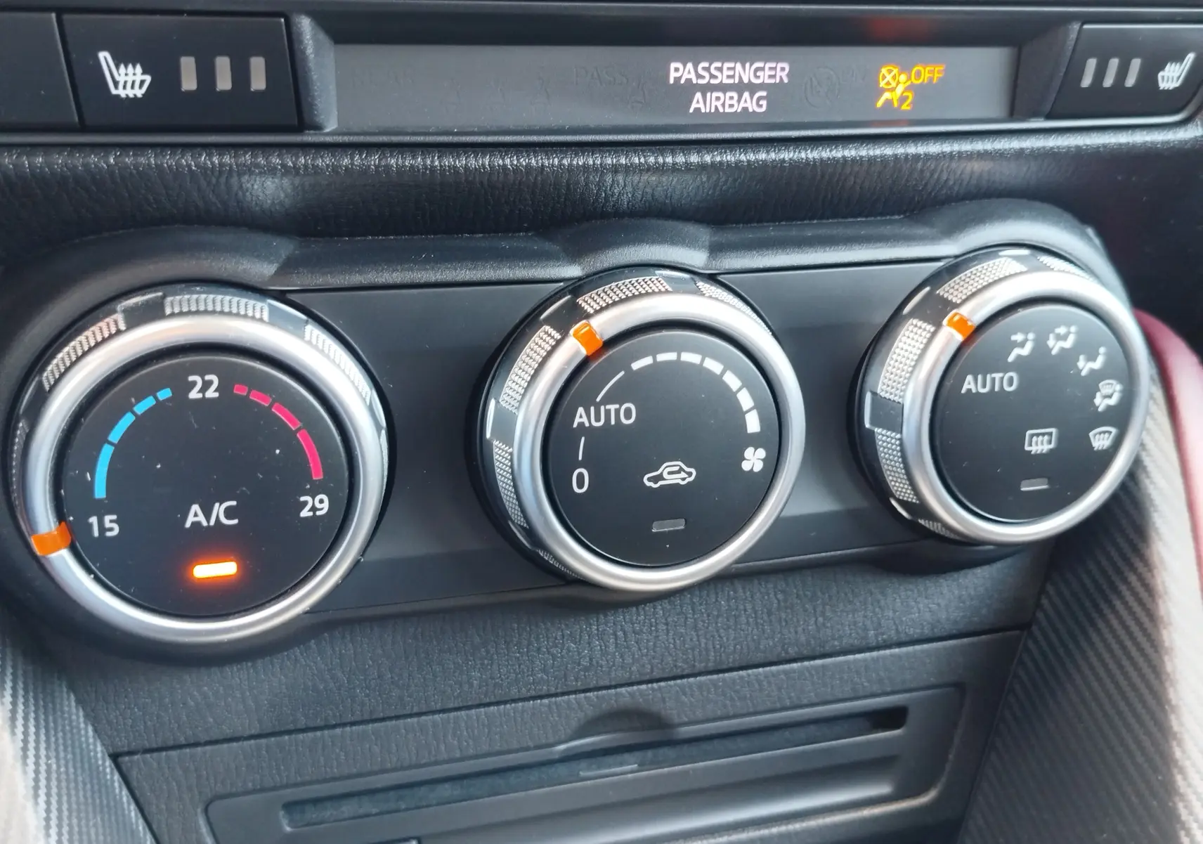 Gros plan sur les commandes de climatisation automatique du Mazda CX-3 2016, avec réglages de température et ventilation.