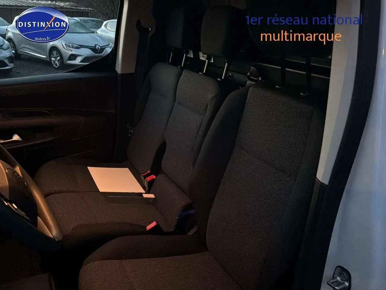 Vue intérieure côté conducteur du Citroën Berlingo Fourgon blanc, montrant les sièges avant et la cloison pleine arrière.