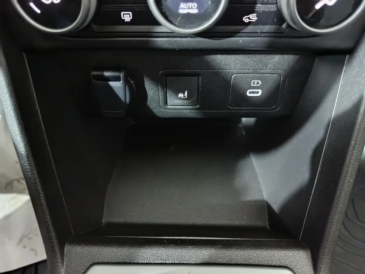 Détail de la console centrale noire de la Dacia Sandero Extreme+ 2024 avec prise USB-C et bouton de siège chauffant.