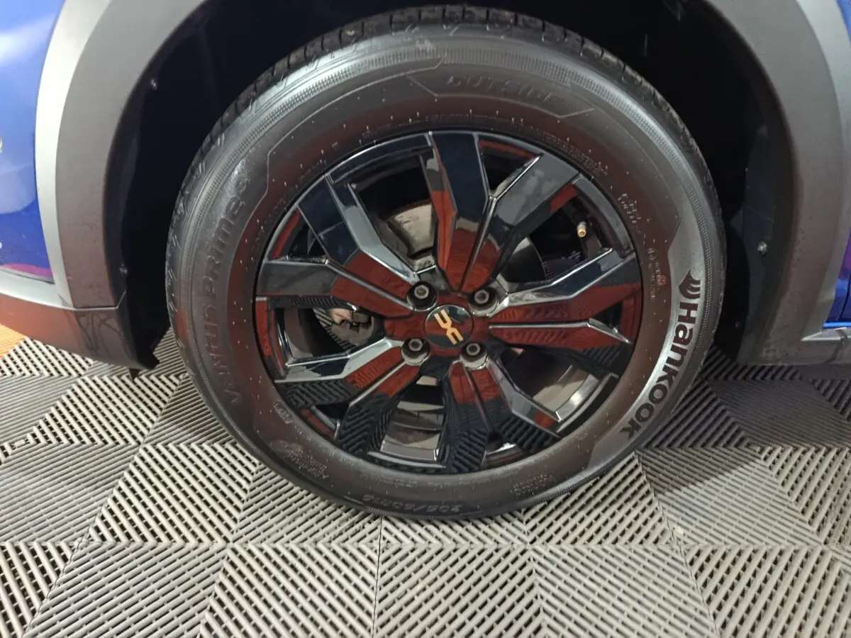 Gros plan sur la roue avant gauche de la Dacia Sandero Extreme+ bleu 2024 avec jante noire brillante et pneu Hankook.