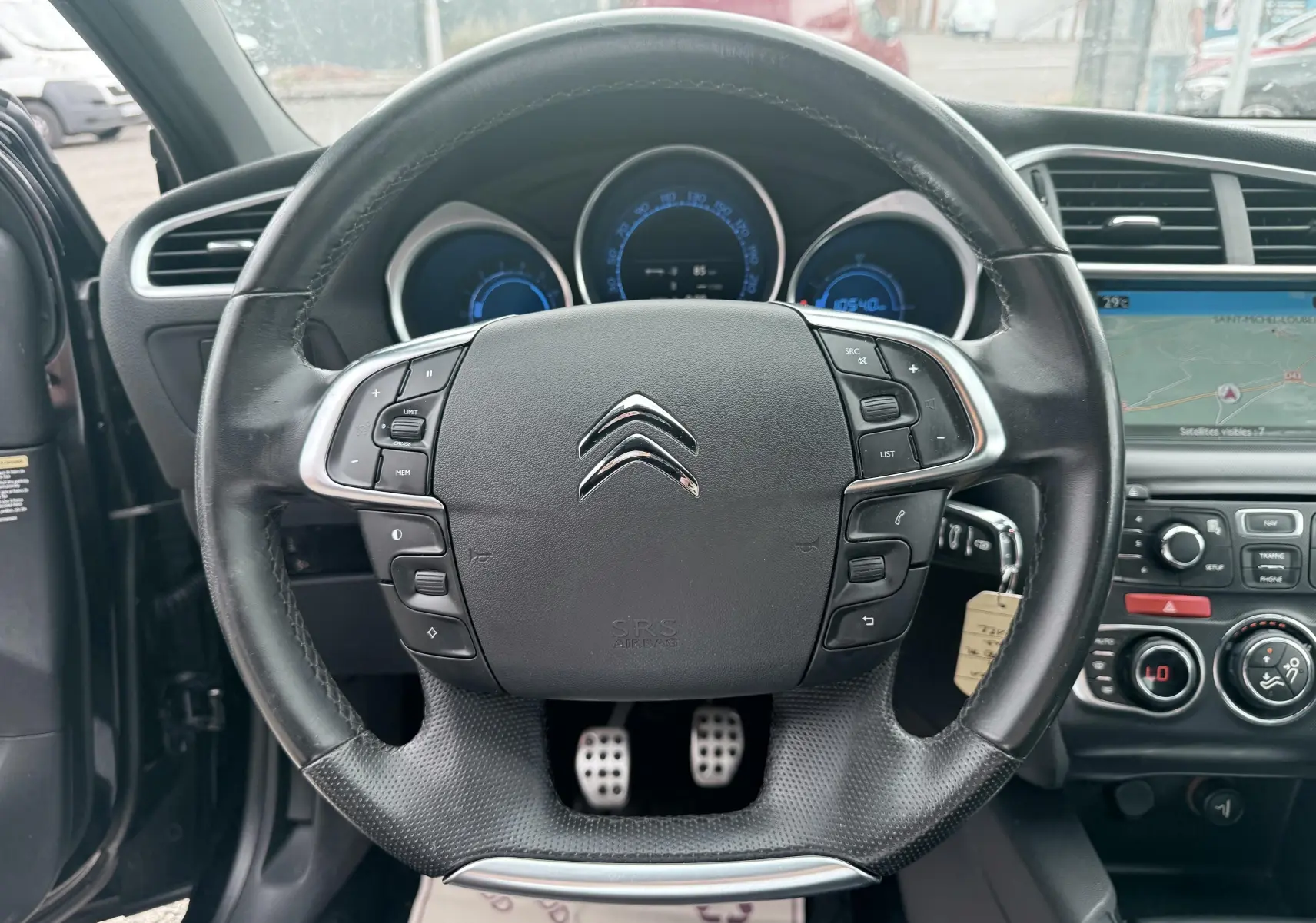Vue intérieure centrée sur le volant noir de la Citroën DS4 2012 avec tableau de bord et écran GPS visible.