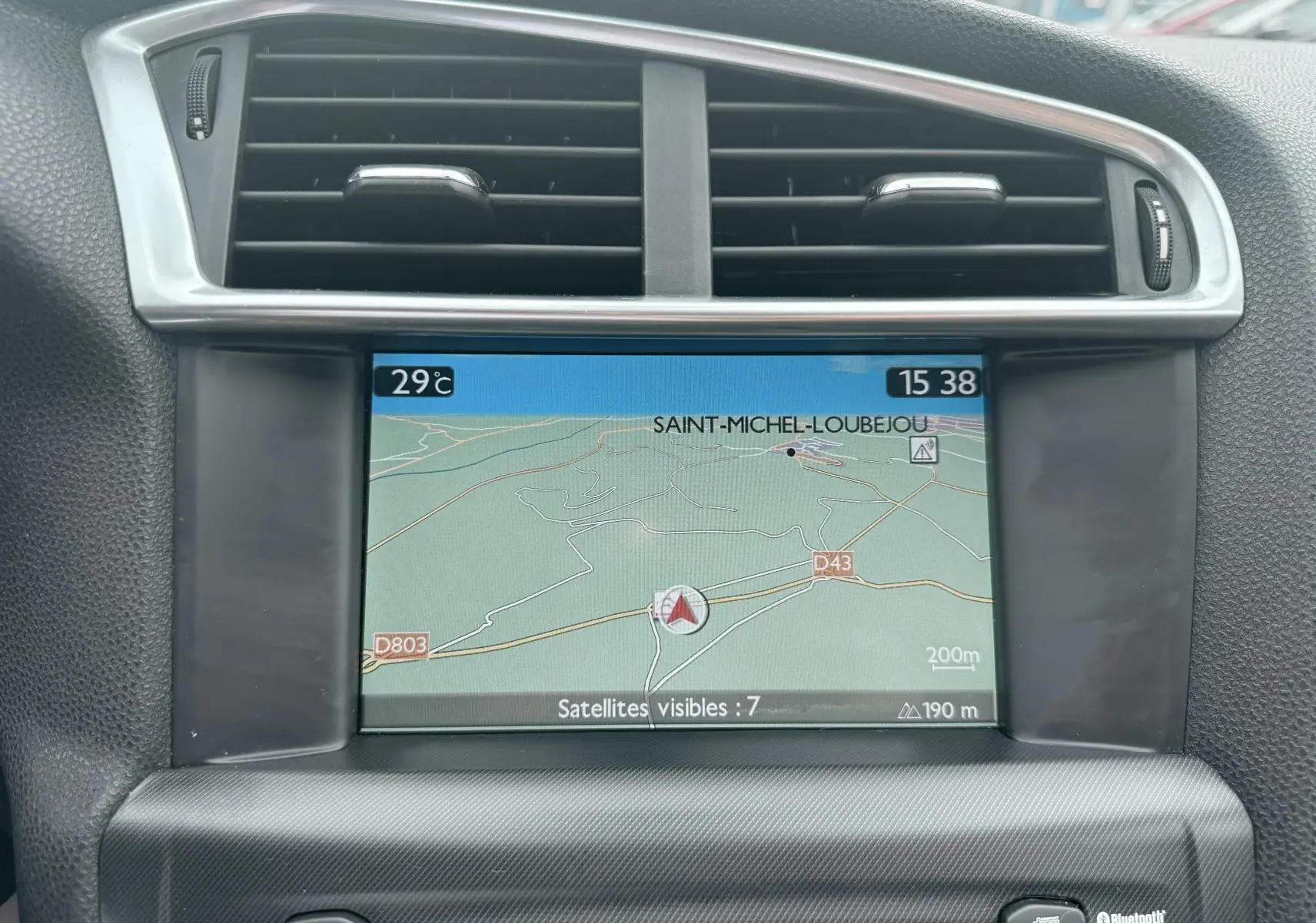 Écran GPS central avec carte routière affichée, entouré d'aérations noires et cadre argenté dans un Citroën DS4 noir.