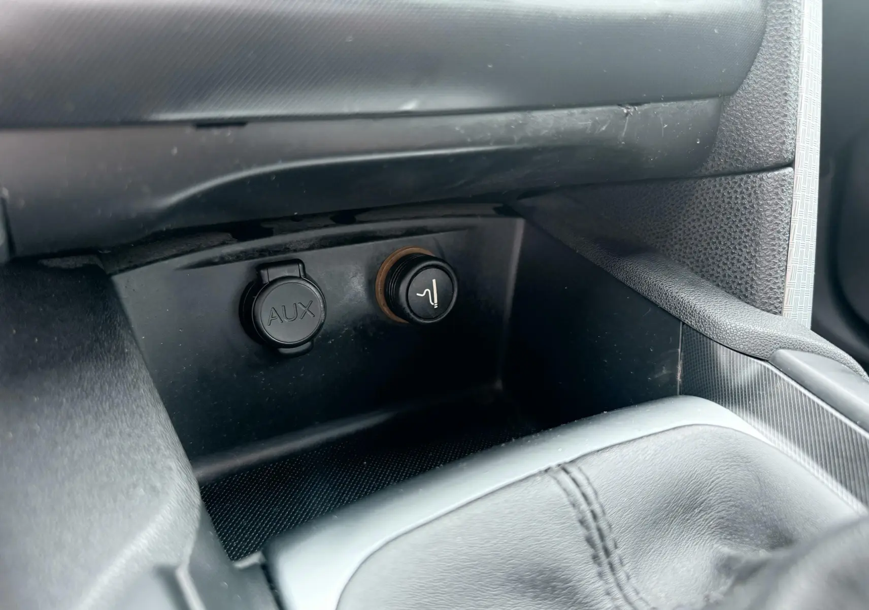 Prise AUX et allume-cigare en gros plan dans l’habitacle noir d’une Citroën DS4 2012.