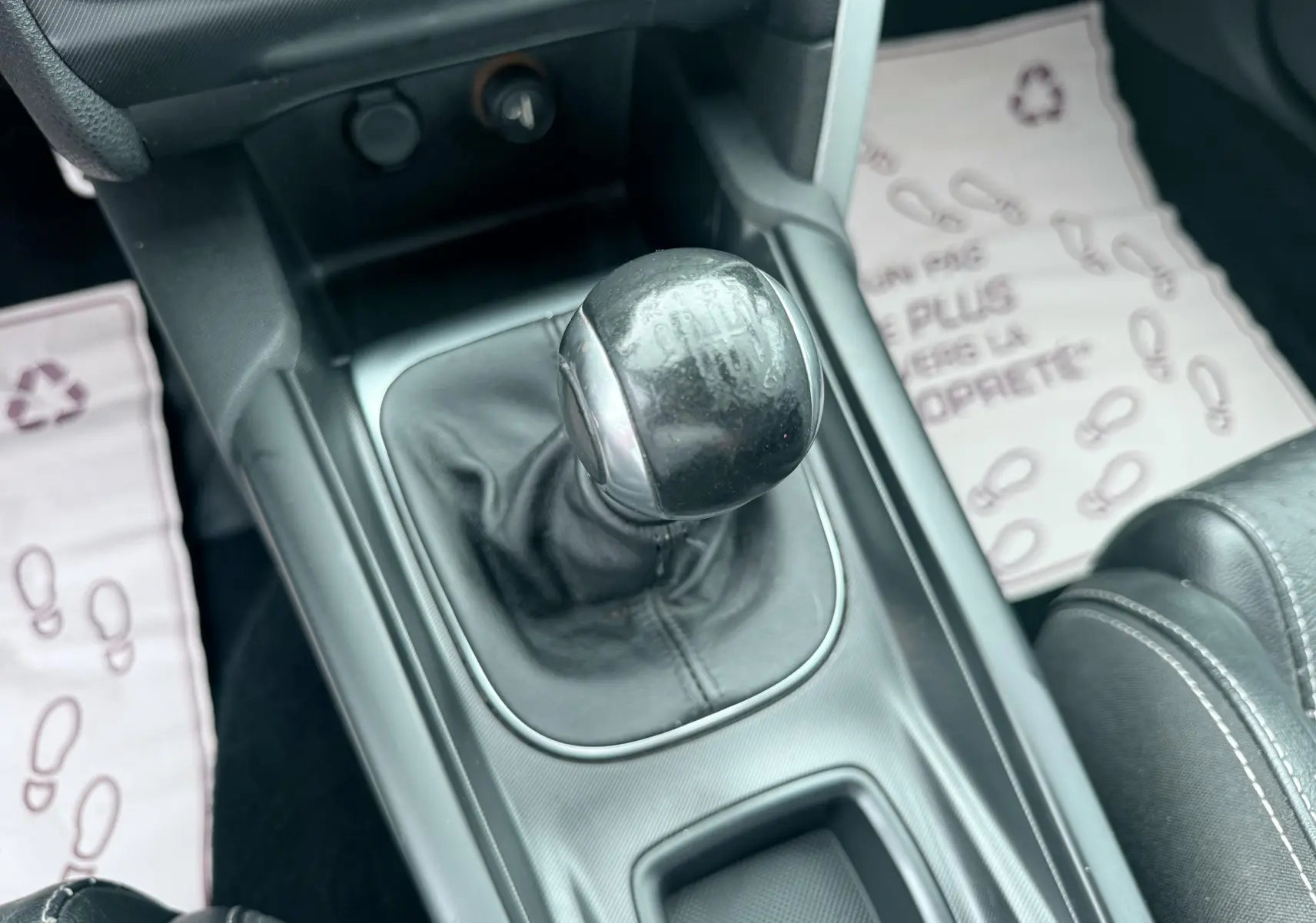 Gros plan sur le levier de vitesses manuel noir de la Citroën DS4, entouré de la console centrale et tapis de sol.