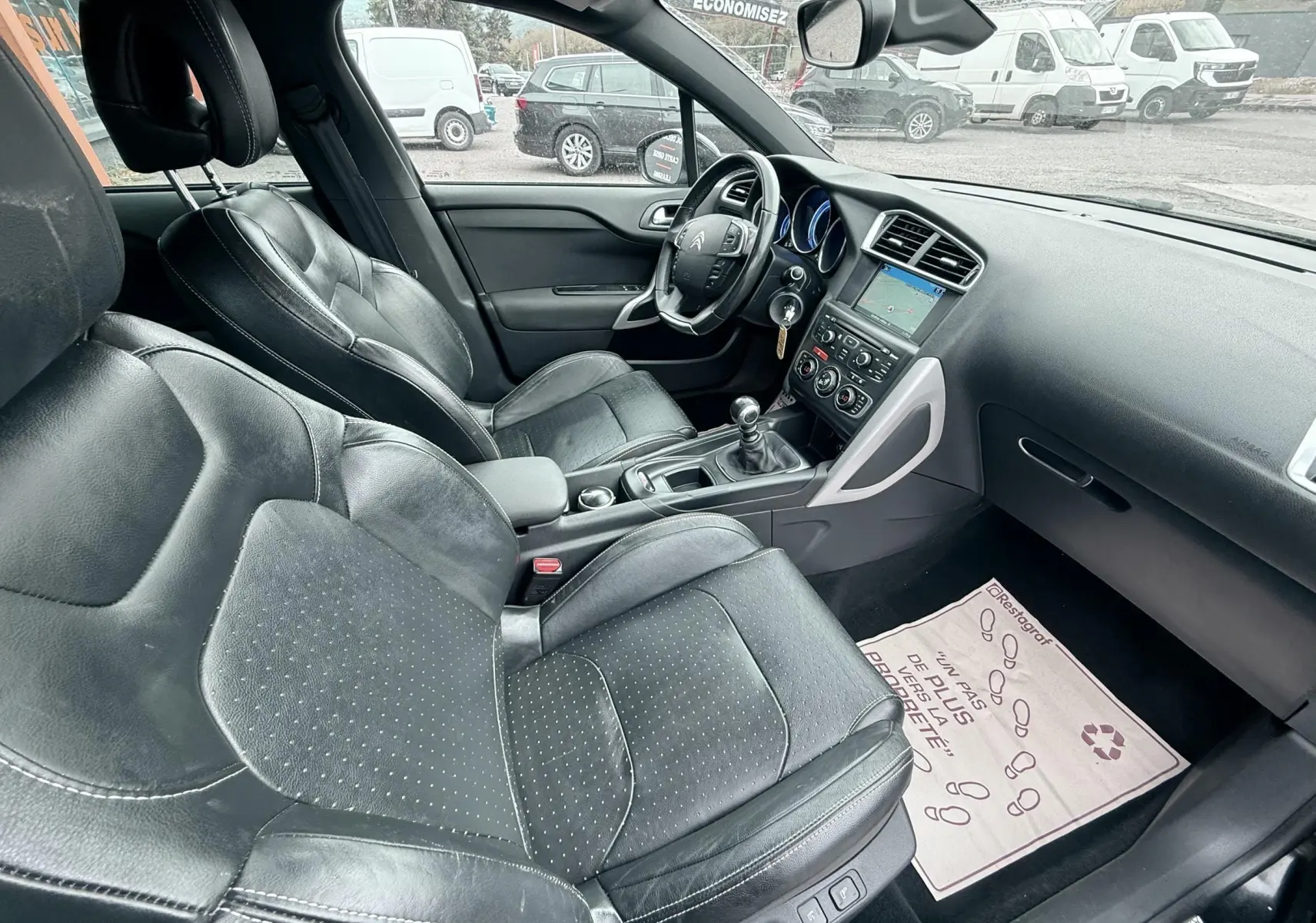 Vue intérieure côté droit de la Citroën DS4 1.6 HDI noire de 2012 avec sièges cuir et tableau de bord moderne.