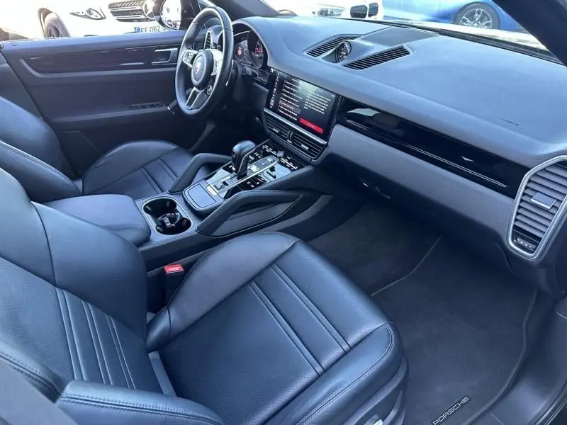 Intérieur noir du Porsche Cayenne 2020, vue côté conducteur, avec tableau de bord moderne et écran tactile central.