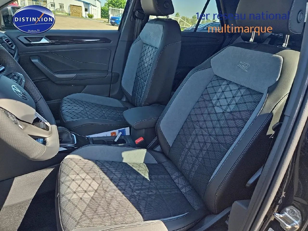 Intérieur du Volkswagen T-Roc 2025, vue côté gauche sur sièges tissu R-line noirs et gris avec volant multifonction cuir.