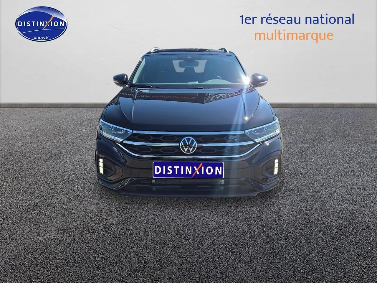 Volkswagen T-Roc noir perle vu de face avec calandre R-Line et feux LED allumés.
