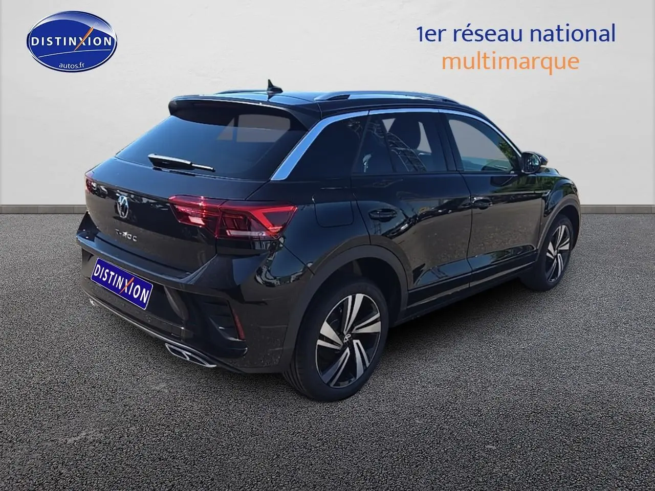 Volkswagen T-Roc noir perle en 3/4 arrière droit, avec jantes alliage et barres de toit argentées visibles.