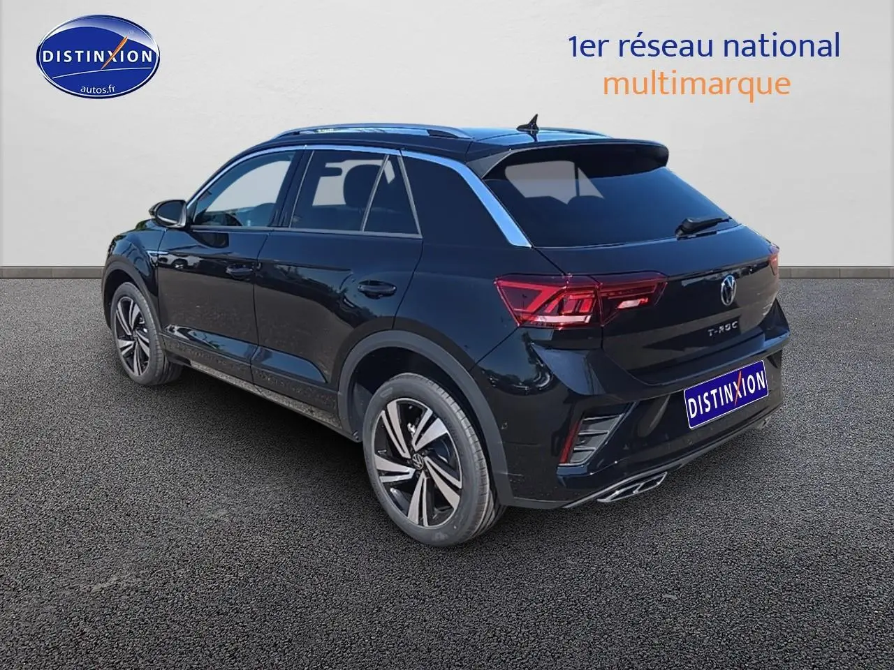 Volkswagen T-Roc noir perle vu 3/4 arrière droit avec jantes alliage et barres de toit argentées.