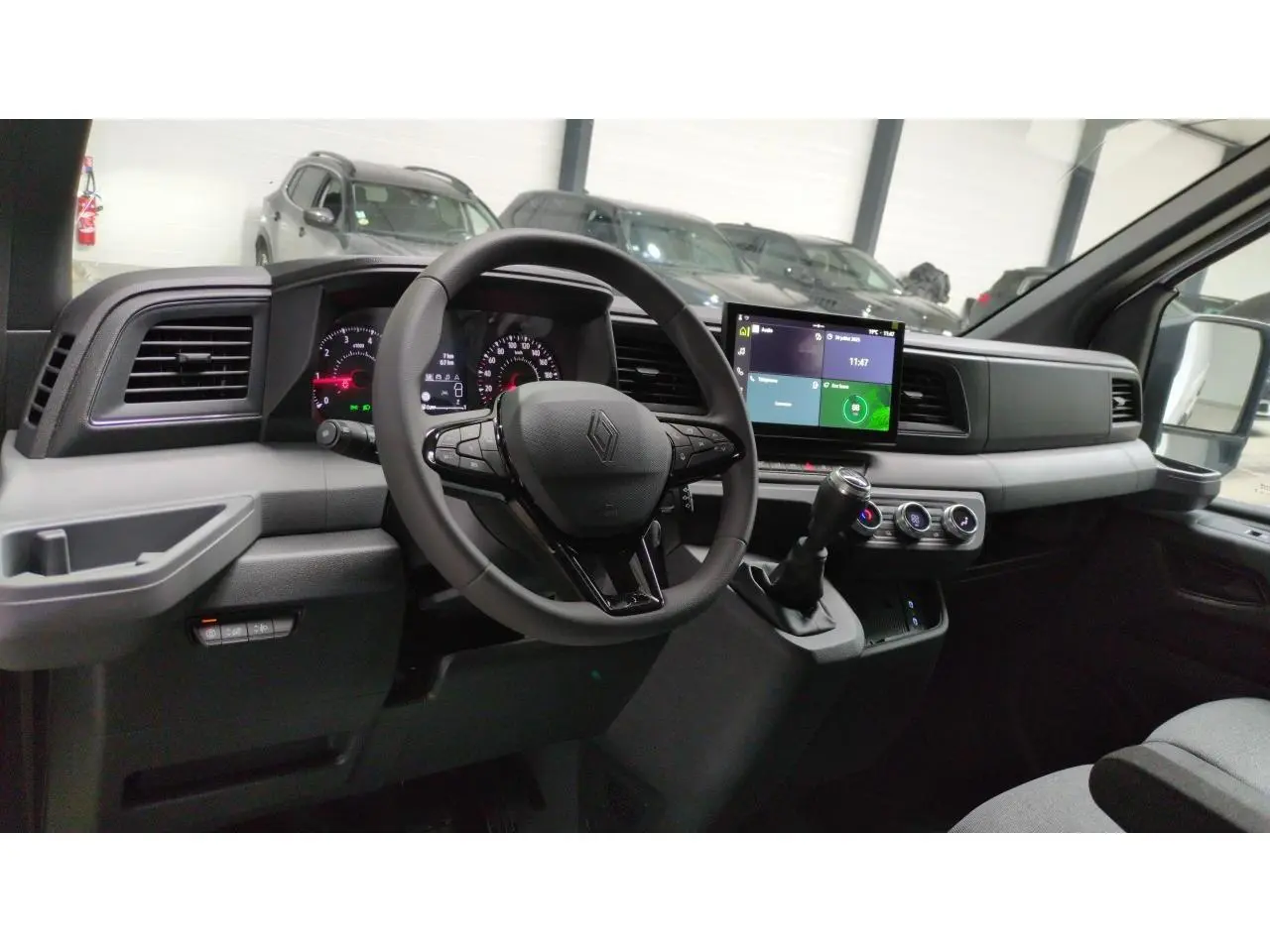 Vue intérieure côté conducteur du Renault Master 2025 avec tableau de bord digital et écran tactile central.