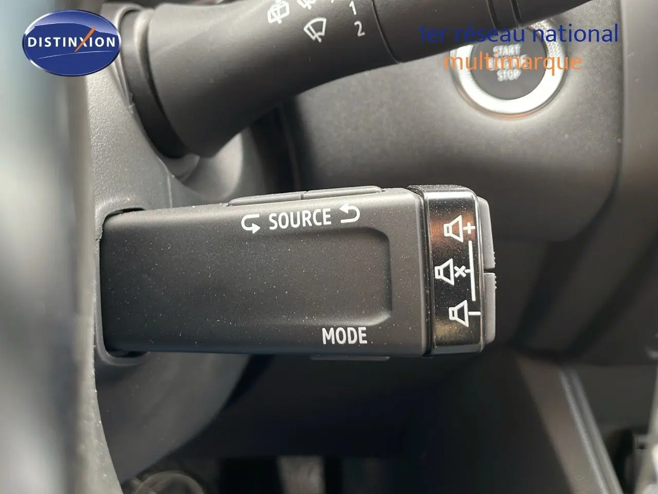 Gros plan sur la commande audio au volant du Renault Captur E-Tech hybride, avec bouton source et mode visibles.