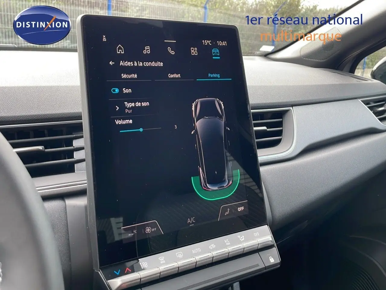 Écran tactile central du tableau de bord du Renault Captur 2025, affichant l'aide au stationnement en intérieur.