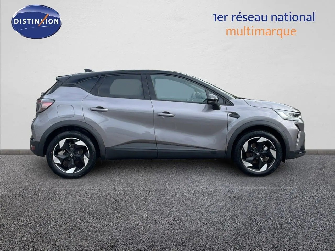 Profil côté gauche du Renault Captur E-Tech hybride gris Cassiopée avec toit noir et jantes noires et argentées.