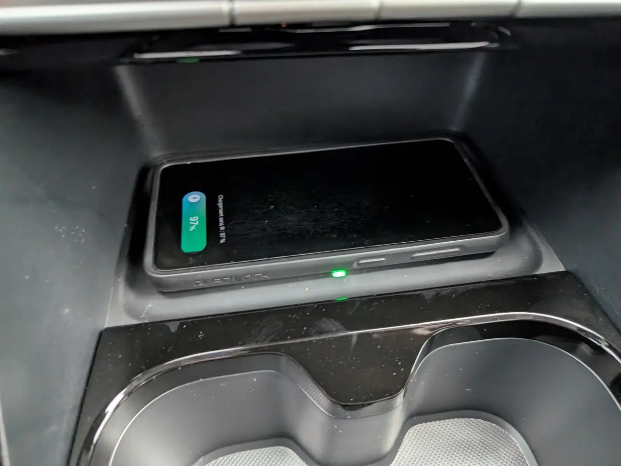 Chargeur sans fil avec smartphone posé dans la console centrale du Citroën C3 Aircross gris métallisé 2025.