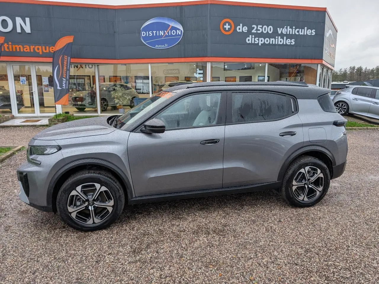 Vue de profil côté gauche d'un Citroën C3 Aircross 2025 gris métallisé avec toit noir Perla Nera et jantes alliage.