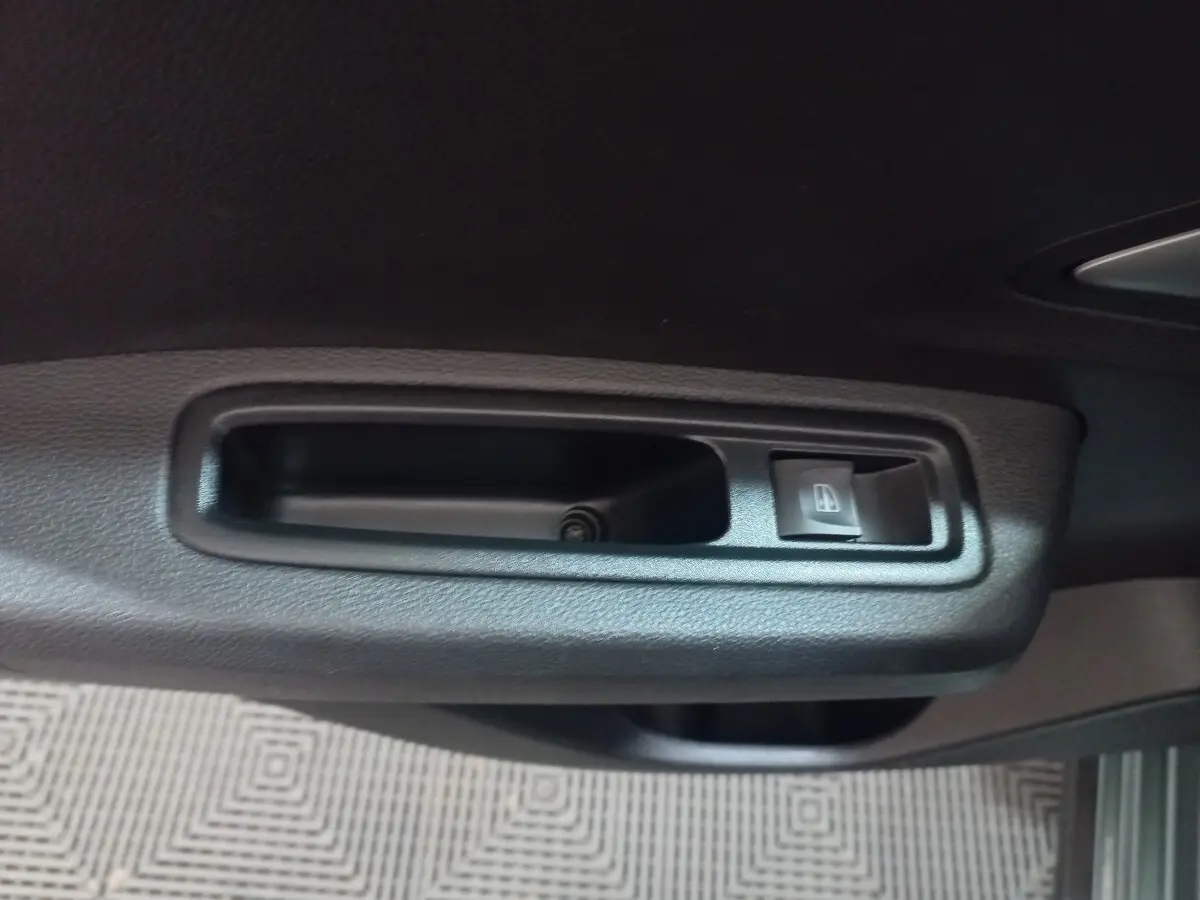 Gros plan sur la commande de lève-vitre côté conducteur de la Dacia Sandero Extreme+ TCe 110 verte 2024.