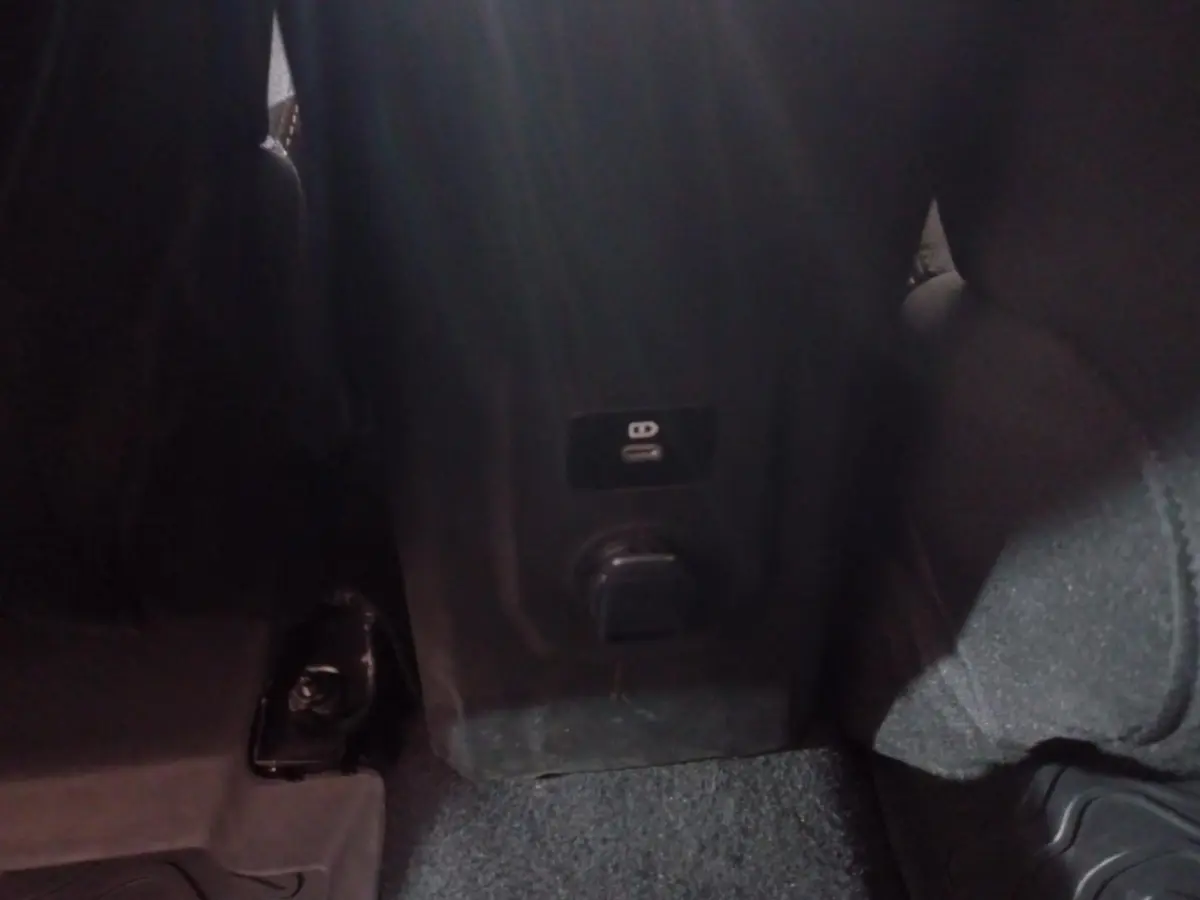 Prise USB et prise 12V arrière sur la console centrale d'une Dacia Sandero Extreme+ TCe 110 verte, vue intérieure arrière.