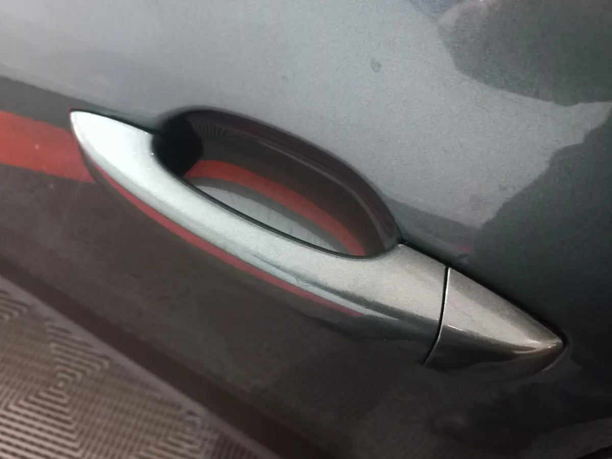 Poignée de porte côté droit gris métallisé sur Dacia Sandero Extreme+ TCe 110 -24, détail extérieur rapproché.
