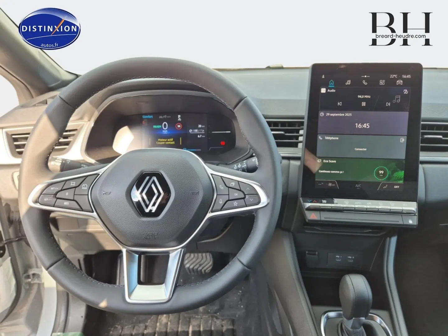 Vue intérieure centrée sur le volant Renault et l'écran tactile vertical du tableau de bord du Captur bleu Iron.