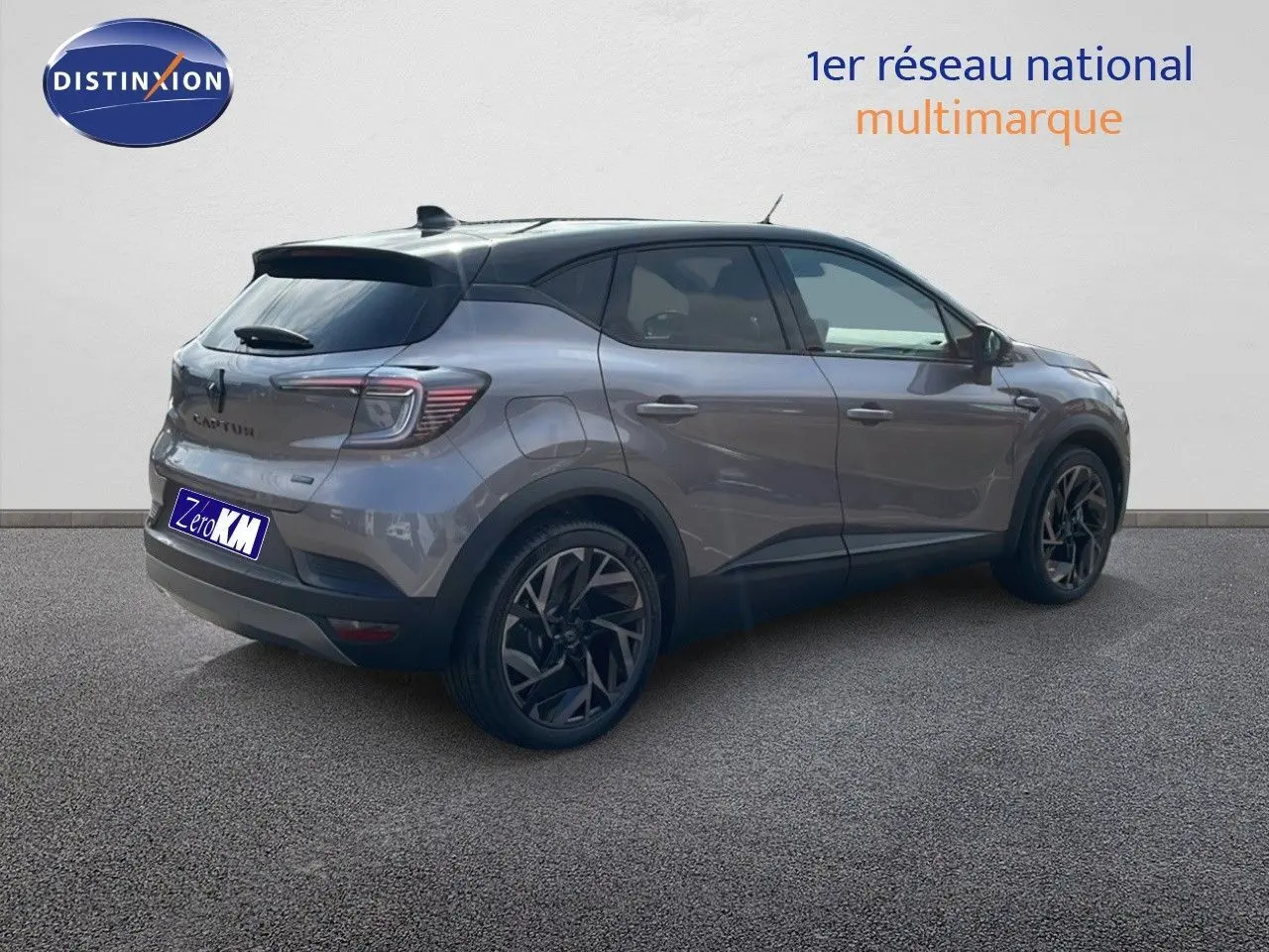 Vue 3/4 arrière droite du Renault Captur E-Tech hybride gris Cassiopée avec toit noir et jantes noires distinctives.