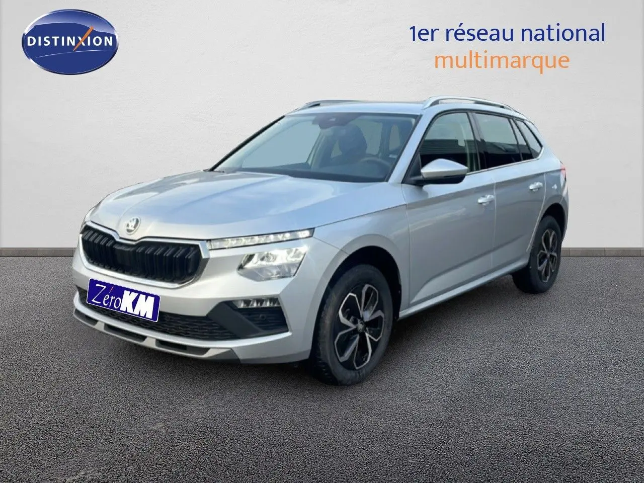 SUV Skoda Kamiq gris argent métal en 3/4 avant droit, avec jantes bi-ton et calandre noire distinctive.