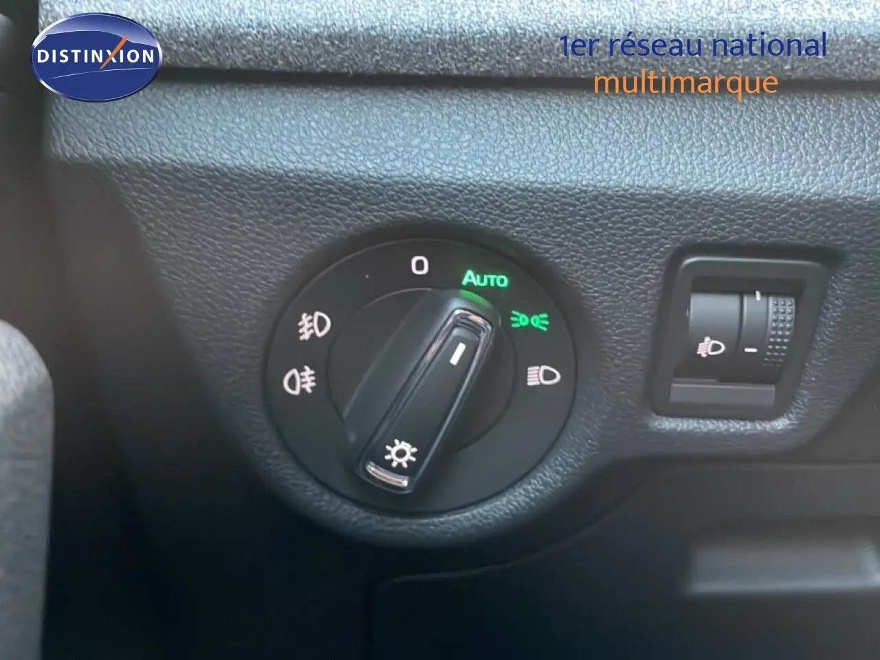 Gros plan sur la molette de réglage des phares du Skoda Kamiq gris argent, avec fonction automatique activée.