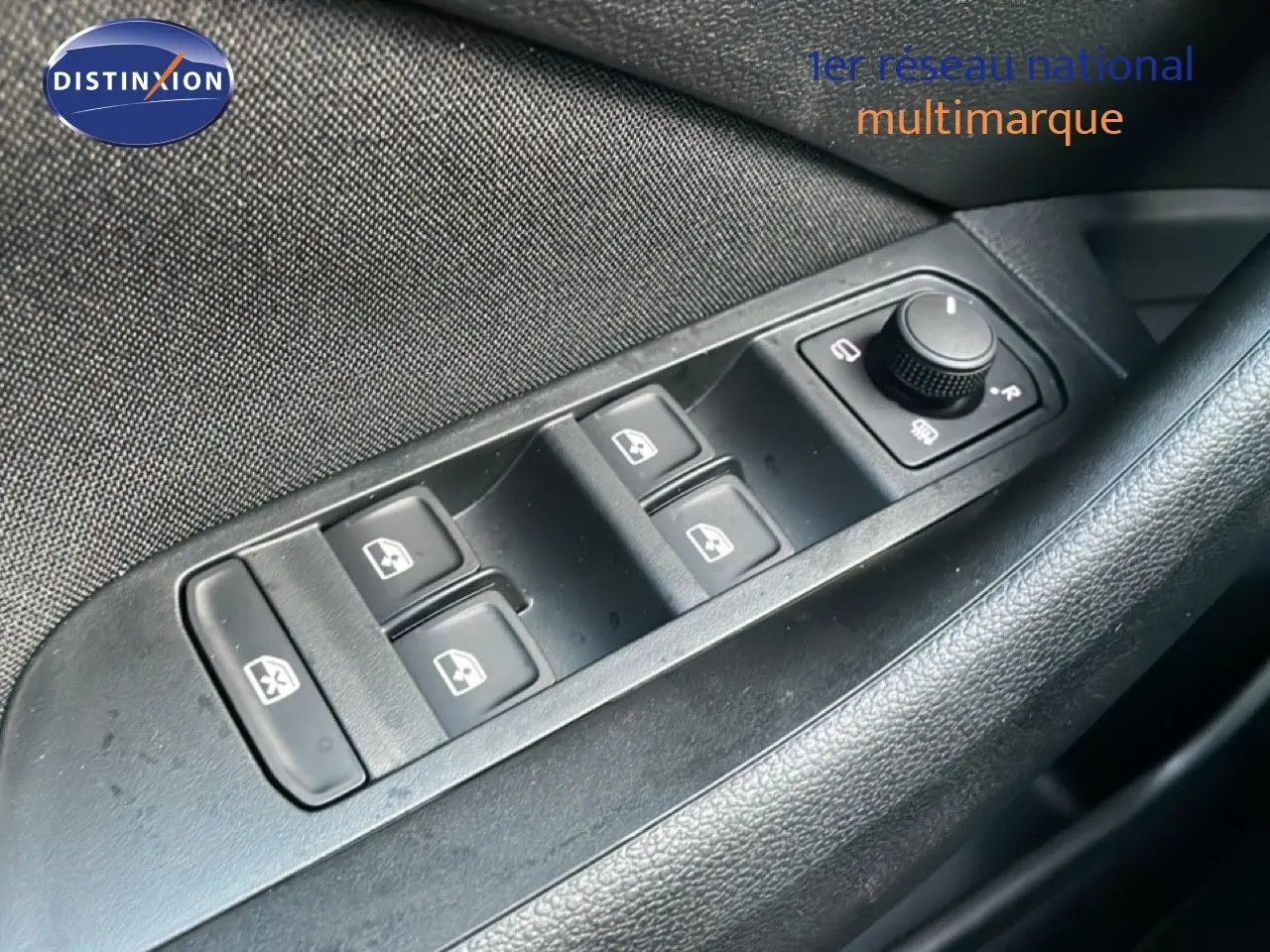 Gros plan sur les commandes des vitres électriques et des rétroviseurs côté conducteur d'une Skoda Kamiq gris argent.