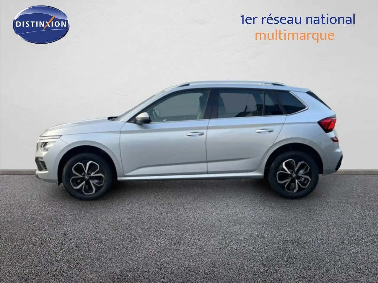 Profil côté gauche d'un Skoda Kamiq gris argent métallisé avec jantes bi-ton et toit ouvrant.