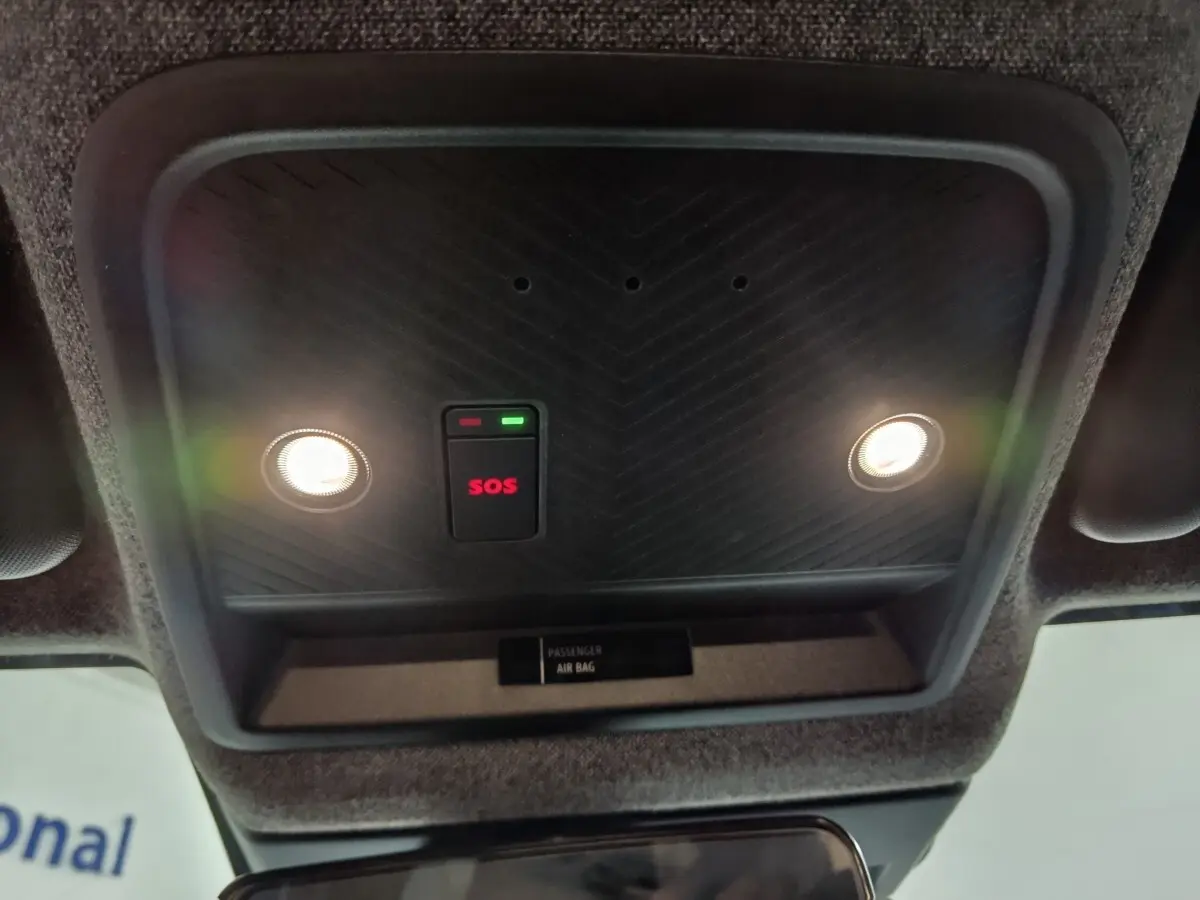 Vue intérieure du plafonnier avec éclairages et bouton SOS rouge allumé sur Dacia Bigster gris foncé.