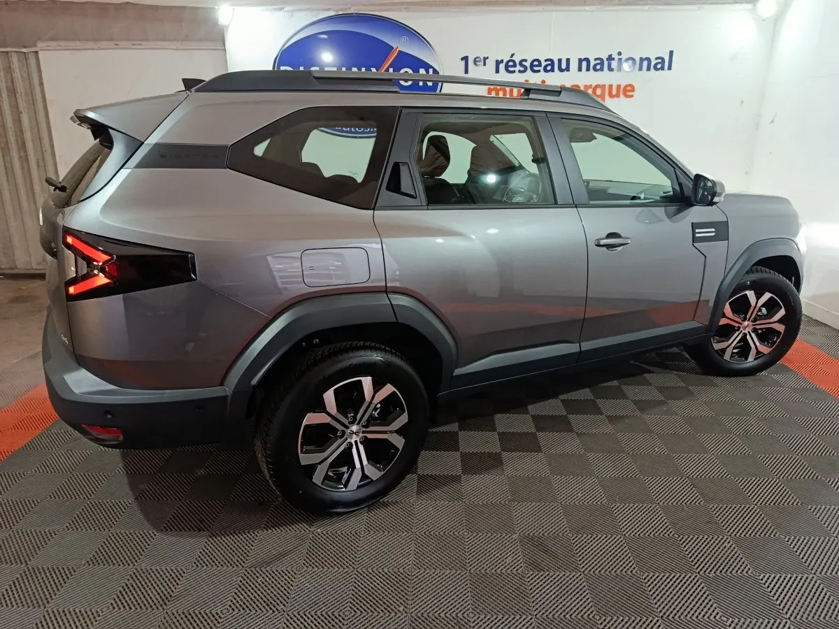 Vue côté droit arrière du Dacia Bigster gris foncé 2025 avec jantes alliage et feux arrière LED distinctifs.