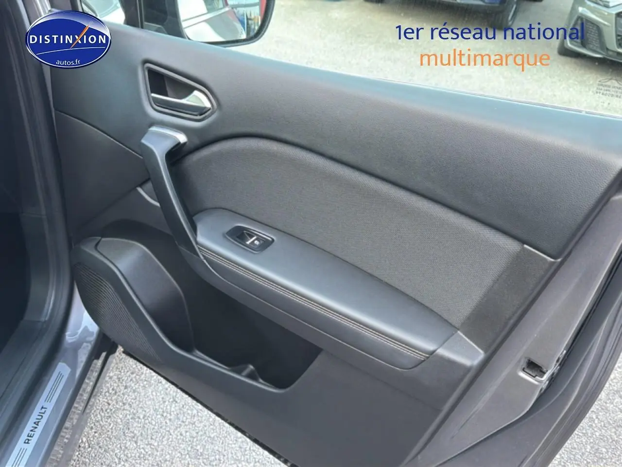 Vue rapprochée de la portière avant gauche grise du Renault Symbioz 2025 avec accoudoir et commande de vitre.