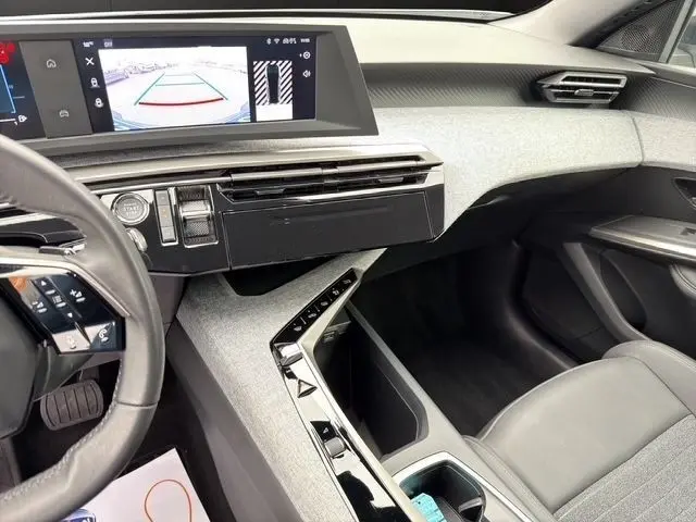 Intérieur avant droit du Peugeot 5008 blanc 2025, tableau de bord moderne avec écran tactile et volant cuir multifonctions.