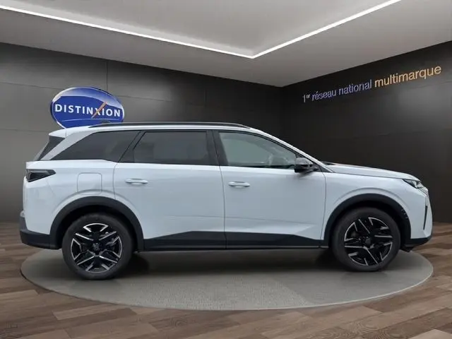 Vue latérale droite d’un Peugeot 5008 blanc 2025 avec toit noir et jantes alliage noires distinctives.