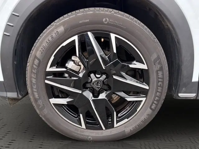 Gros plan sur la roue avant droite du Peugeot 5008 blanc, jante alliage noire et argent avec pneu Michelin.