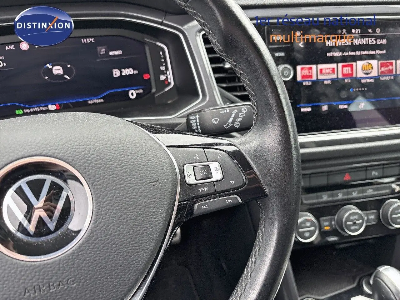 Vue rapprochée du volant en cuir noir et du tableau de bord numérique du Volkswagen T-Roc blanc Silver 2021.