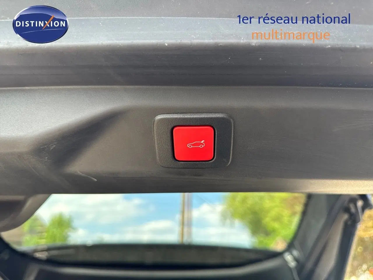 Bouton rouge d'ouverture électrique du hayon, vu de l'intérieur du coffre d'un Peugeot 3008 blanc Okenite 2025.