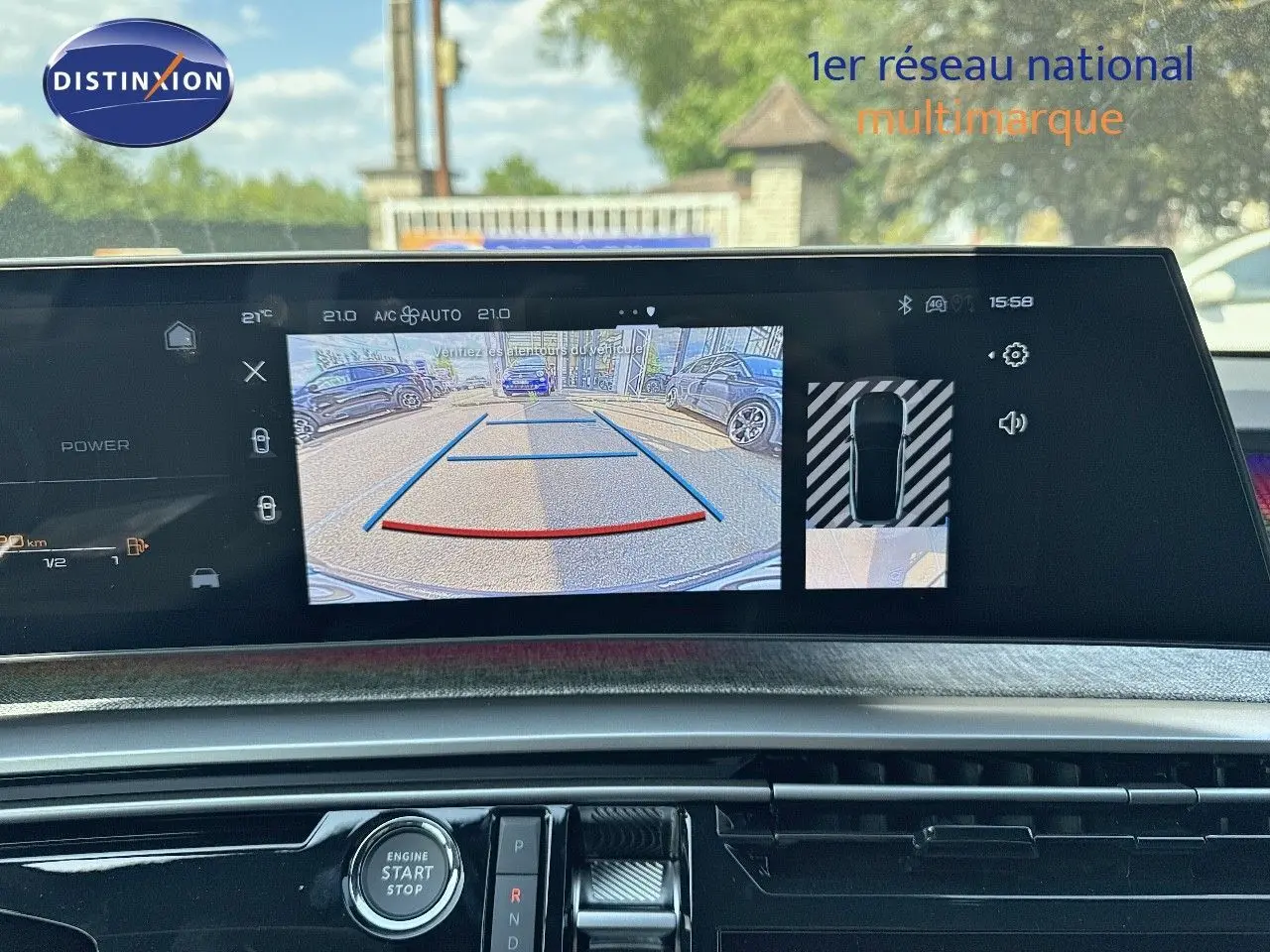 Vue intérieure du tableau de bord du Peugeot 3008 blanc Okenite 2025, écran affichant la caméra de recul et les commandes.