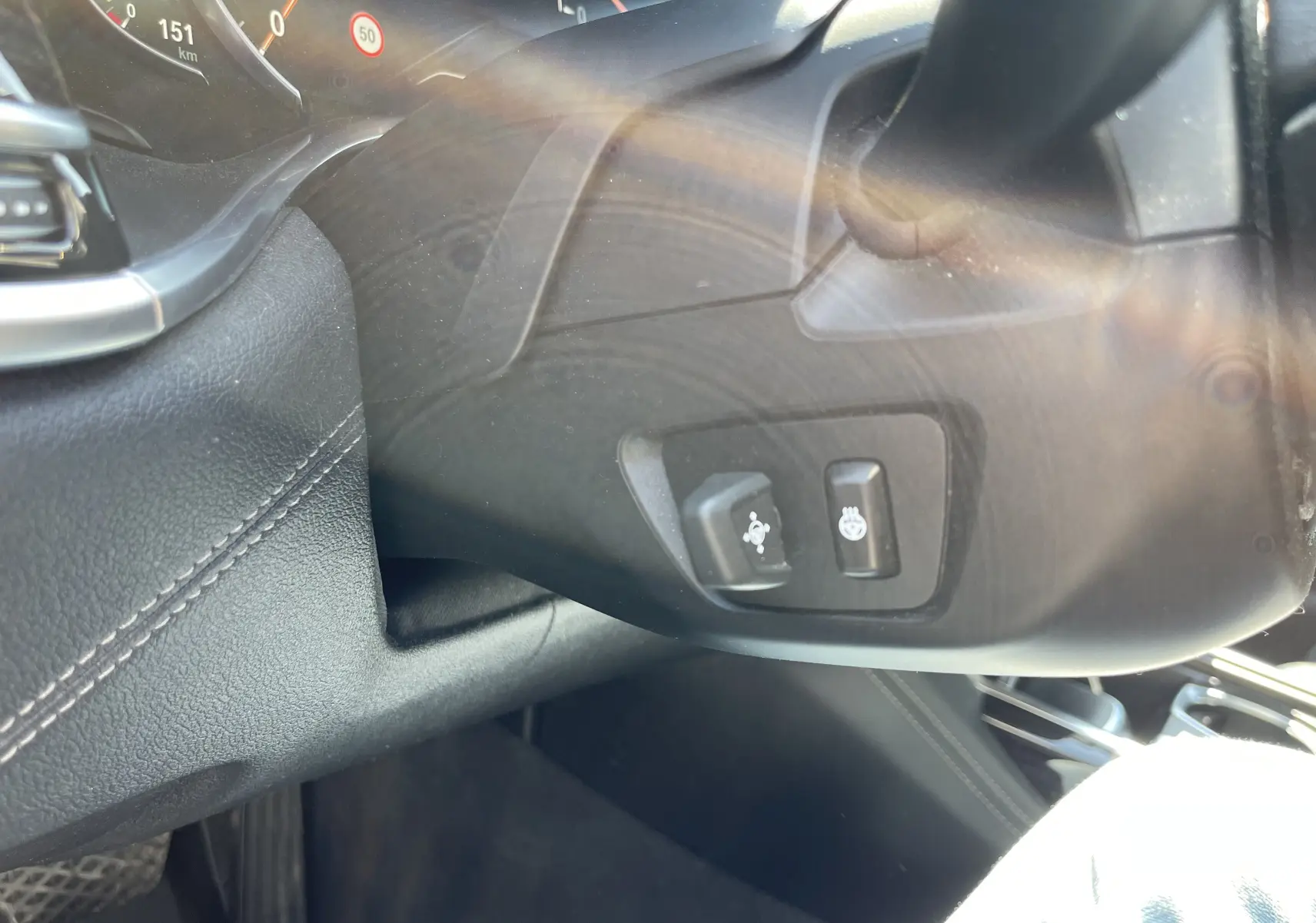 Détail du tableau de bord noir côté gauche d'une BMW Série 7 G11 avec commandes de réglage du volant et chauffage intégré.