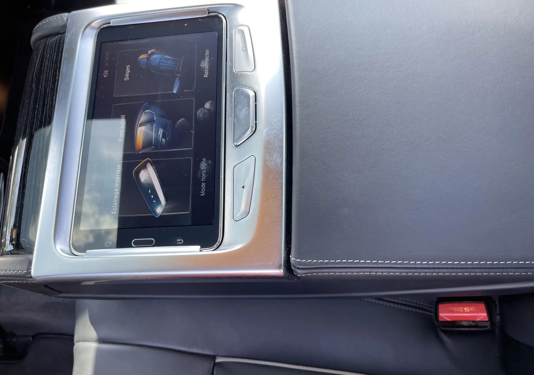 Vue rapprochée de la console centrale noire en cuir avec écran tactile affichant les réglages sièges et éclairage intérieur d'une BMW Série 7 G11.