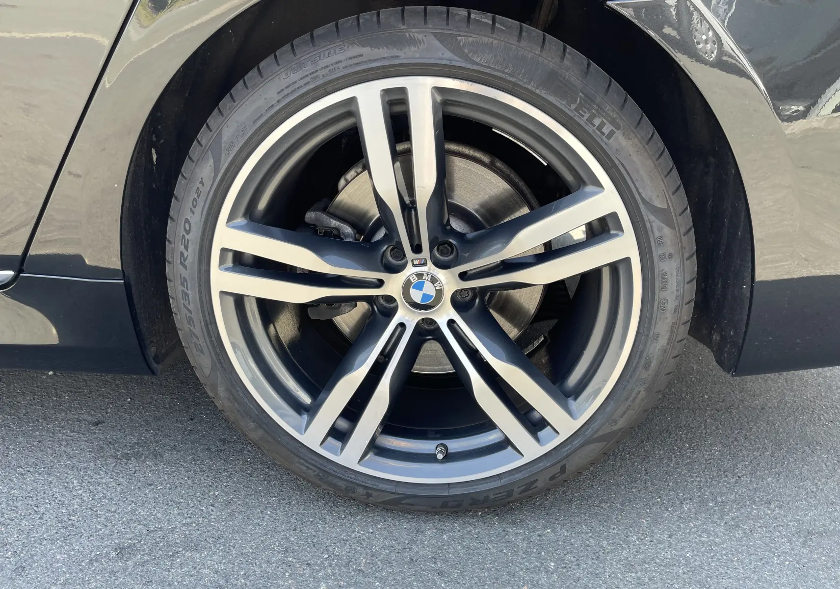 Gros plan sur la roue avant droite noire d'une BMW Série 7 G11 M Sport avec jante alliage cinq branches.