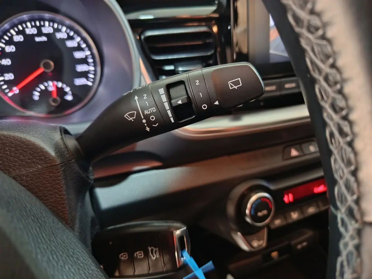 Gros plan sur la commande d’essuie-glace à gauche du volant dans l’habitacle du Kia Stonic gris clair 2022.