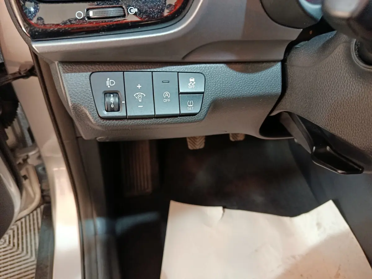 Vue intérieure côté gauche du tableau de bord gris du Kia Stonic 2022, avec commandes d’éclairage et aides à la conduite.