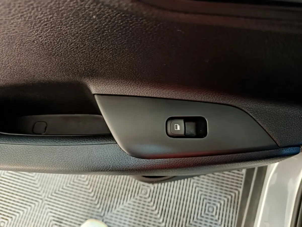 Gros plan sur le bouton de verrouillage centralisé sur la porte côté conducteur d'un KIA Stonic gris clair 2022.