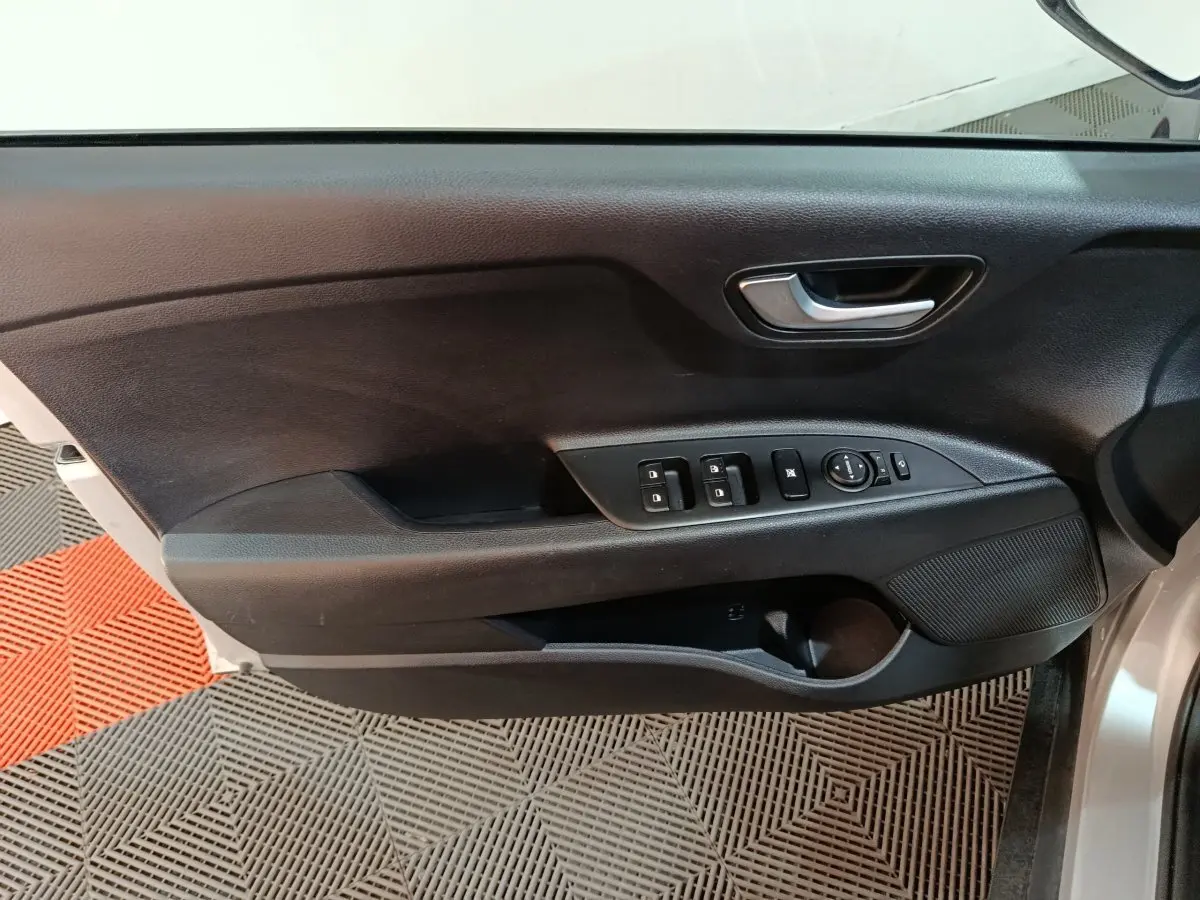 Vue rapprochée de la porte avant gauche noire du Kia Stonic gris clair, avec commandes électriques des vitres et rétroviseurs.