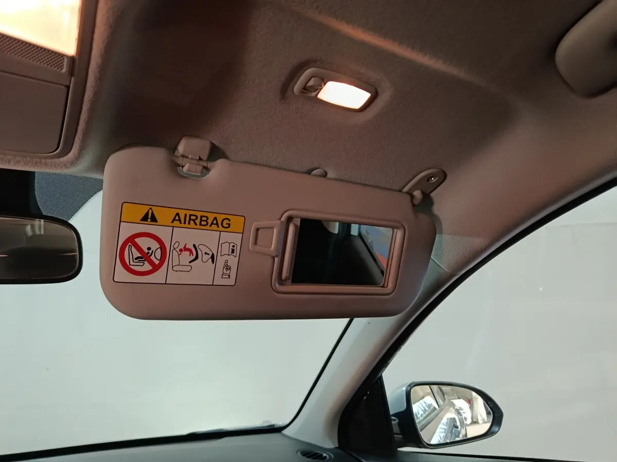 Vue intérieure du pare-soleil côté conducteur avec miroir et avertissement airbag dans un Kia Stonic gris clair 2022.