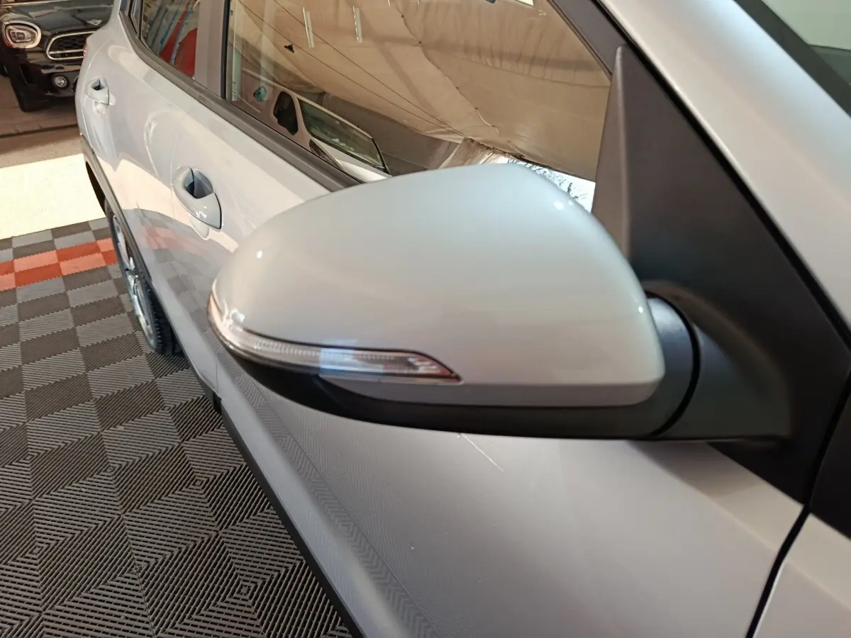 Gros plan sur le rétroviseur côté gauche gris clair du KIA STONIC 1.0 T-GDI 100 URBAN 2022, avec porte et poignée visibles.