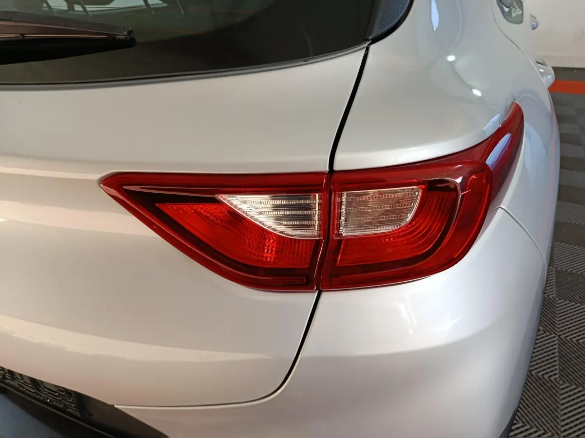 Gros plan sur le feu arrière droit du KIA STONIC gris clair, mettant en valeur la finition lisse de la carrosserie.